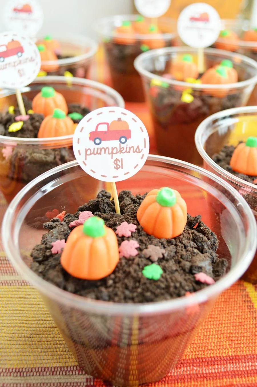 close up of plastic cups filled with dirt pudding and cute pumpkin decorations