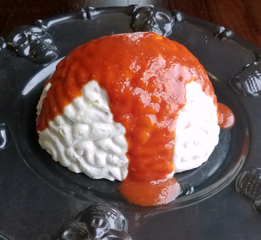 brain shaped shrimp spread with cocktail sauce blood poured over top.