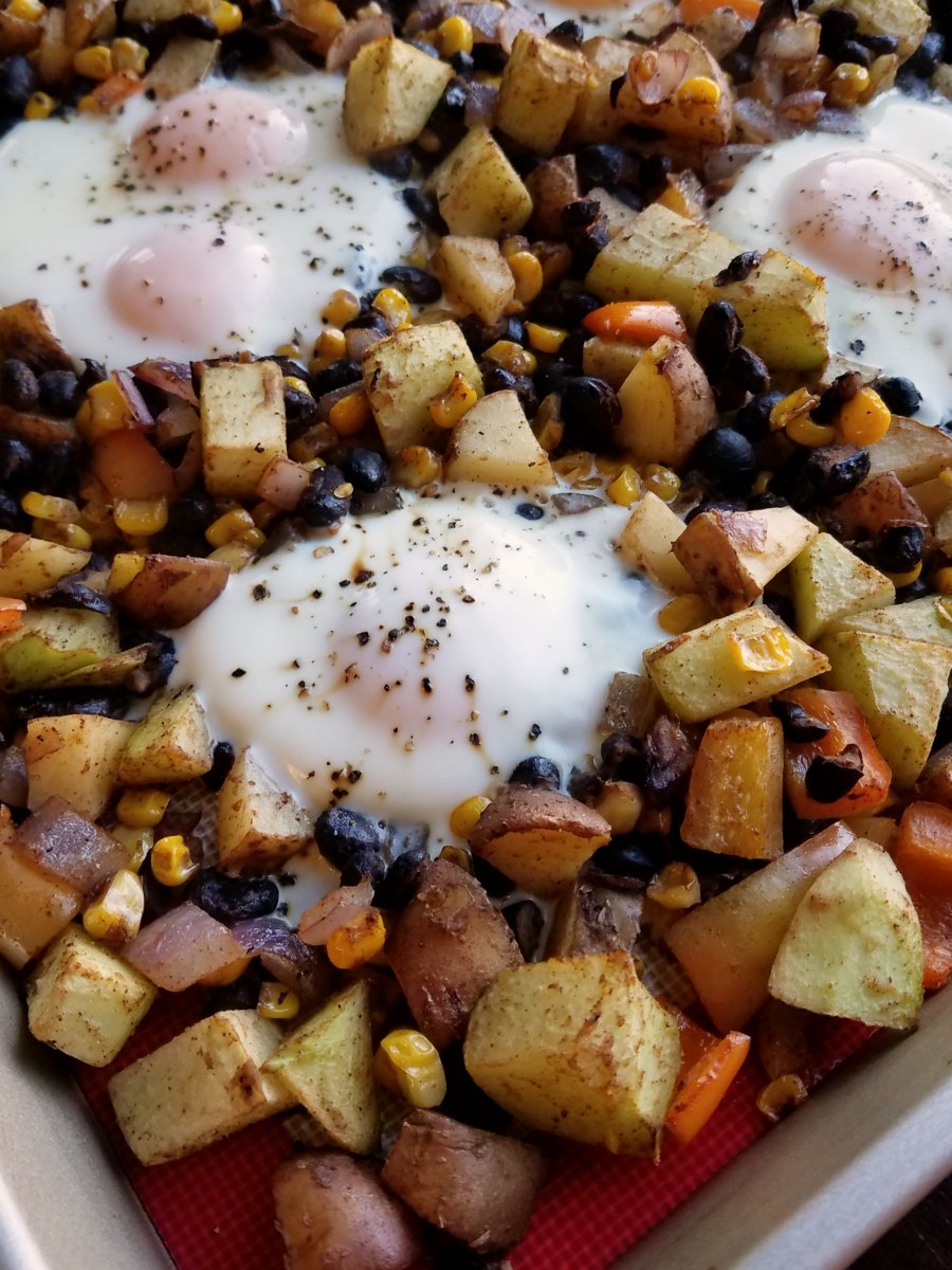 close up of corner of pan showing roasted veggies and cooked eggs.