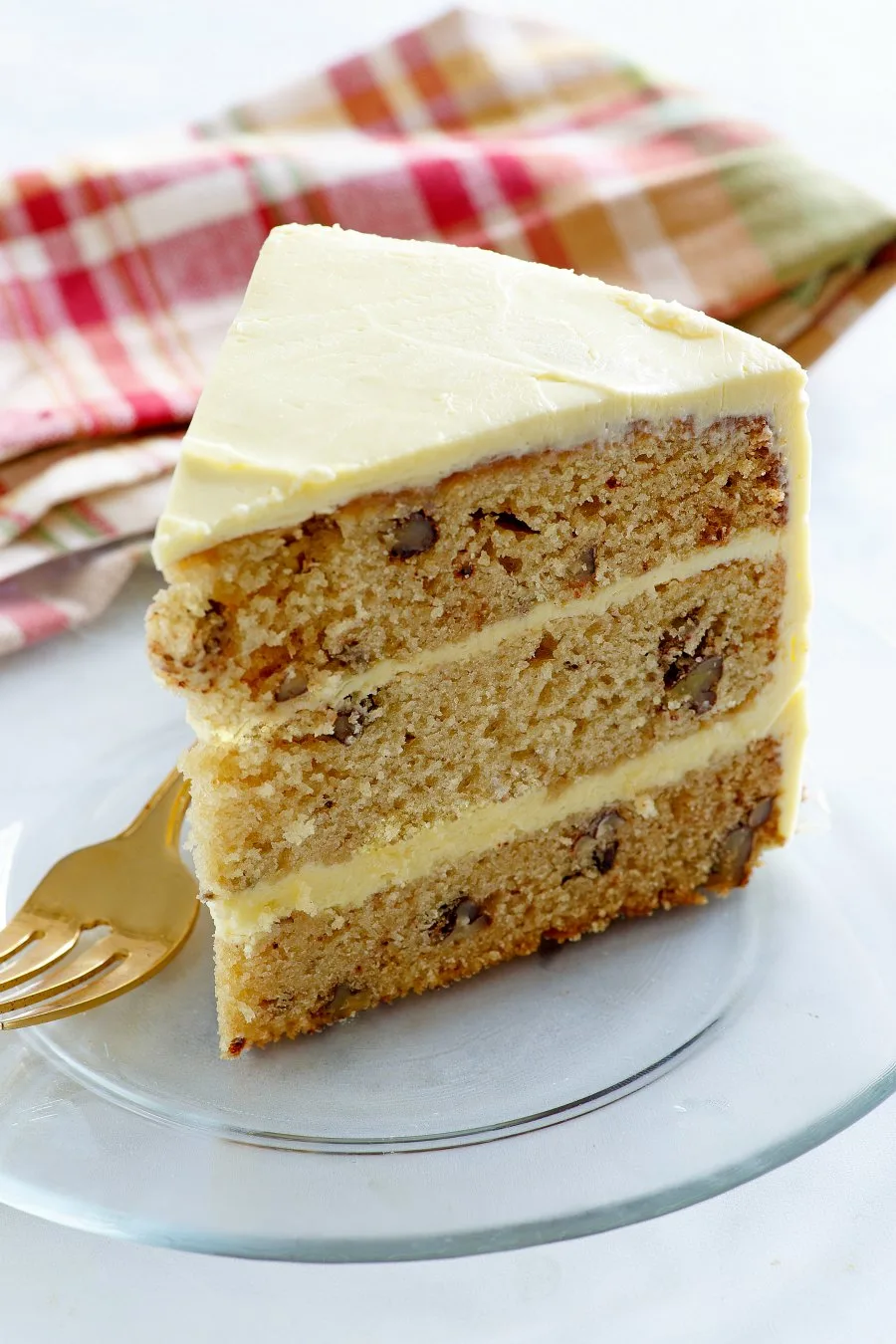 slice of three layer cake with maple and pecans with maple frosting.