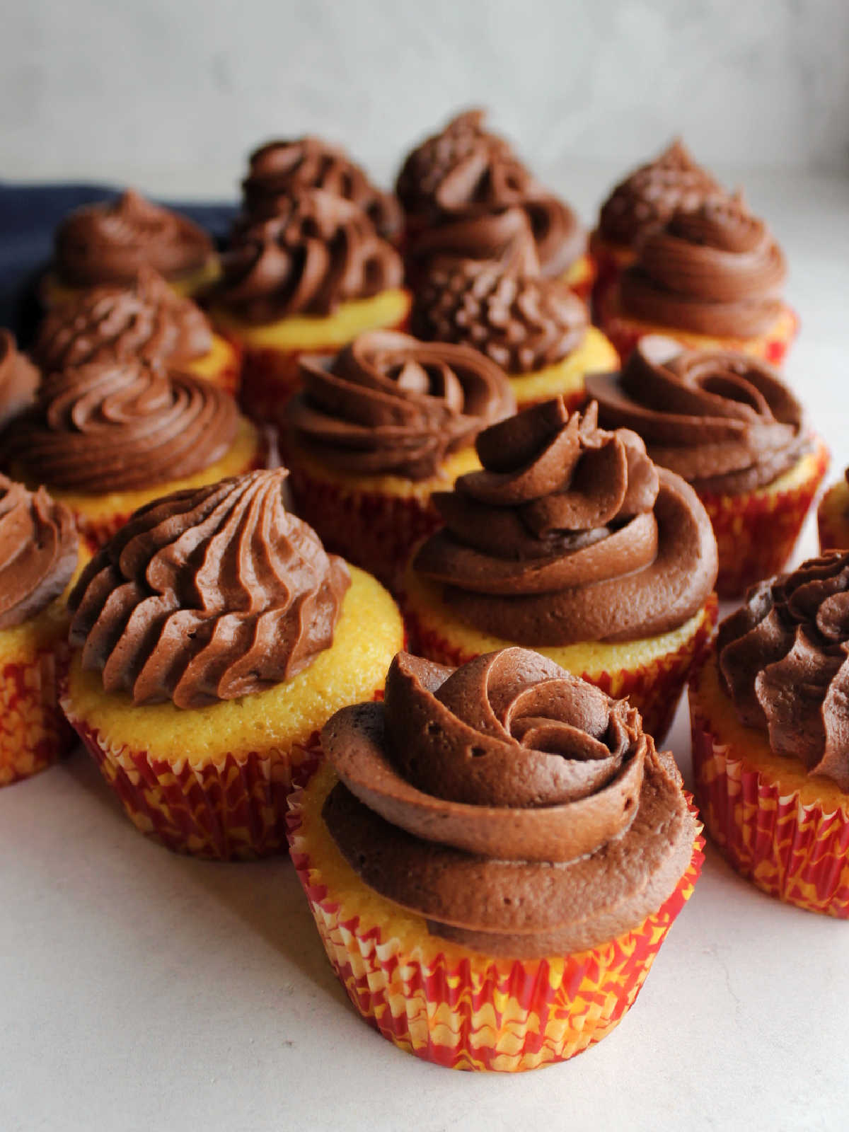 Buttery cupcakes topped with chocolate fudge frosting for piping.