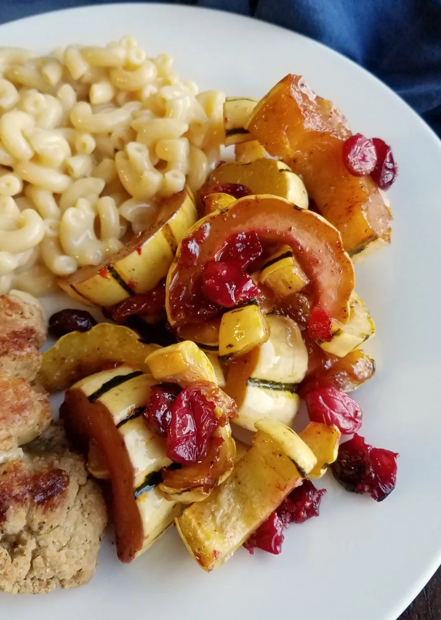 Dinner plate with macaroni and cheese, chicken, and roasted delicata squash with burst cranberries and a honey glaze.