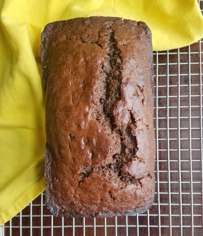 loaf of chocolate banana sourdough quick bread on cooling rack.