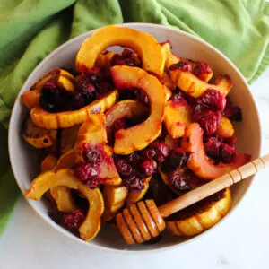 Bowl of honey roasted delicata squash and cranberries ready to eat.