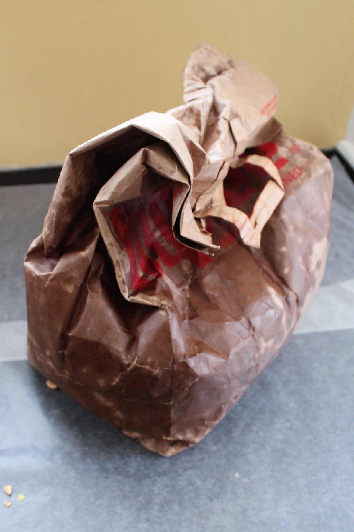 Crumbled brown paper grocery bag after being microwaved and shaken with caramel chex mix inside. 