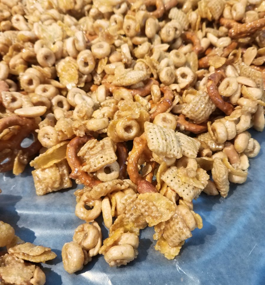 caramel coated snack mix on wax paper cooling.