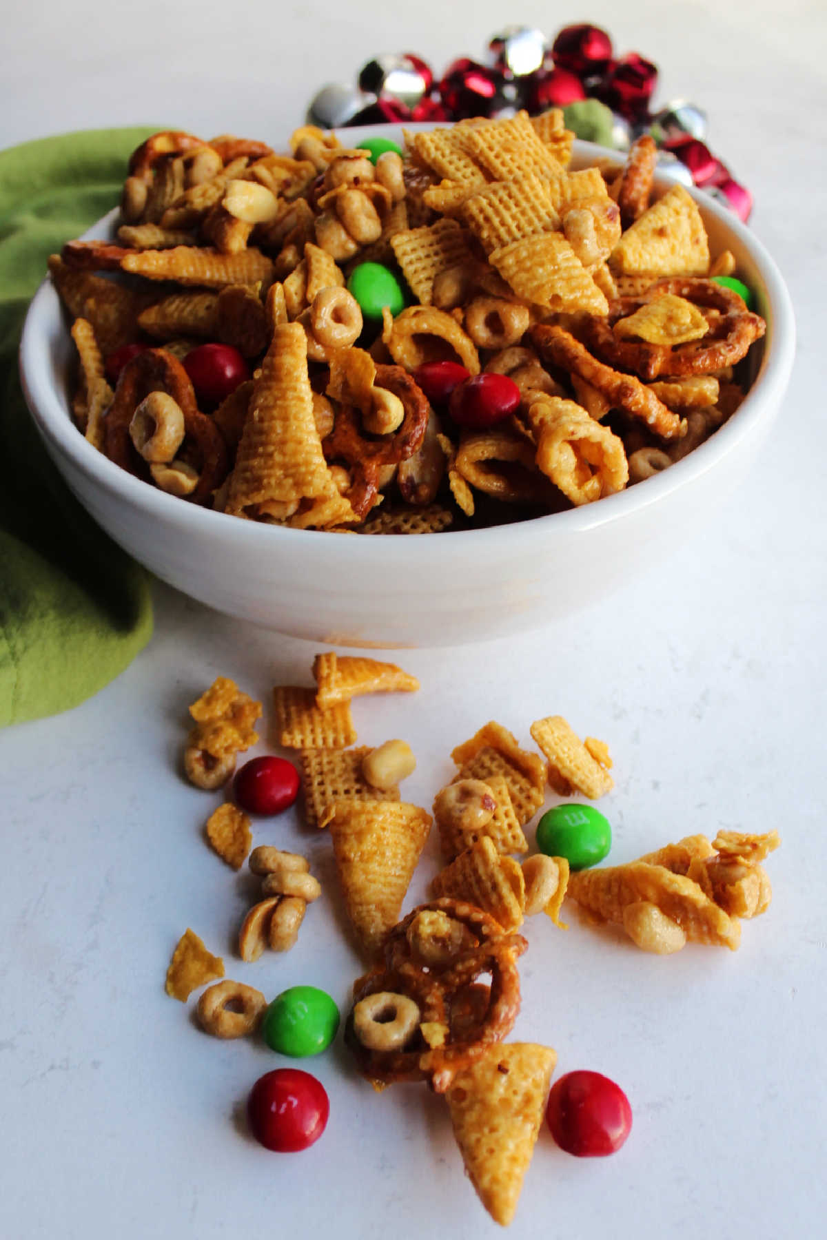 Bowl of crunchy caramel bugle mix with pretzels, cereal, peanuts and red and green M&M's ready to eat. 