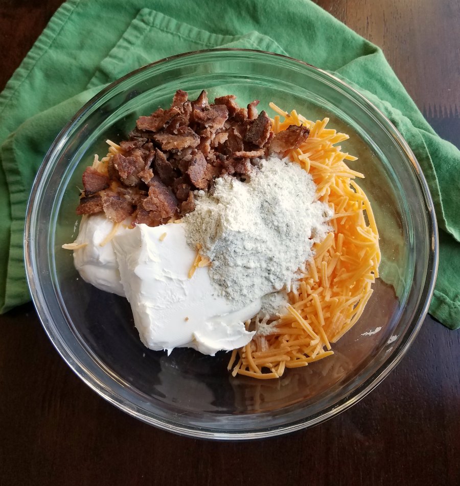 bowl filled with cream cheese, ranch seasoning, cheese and bacon.