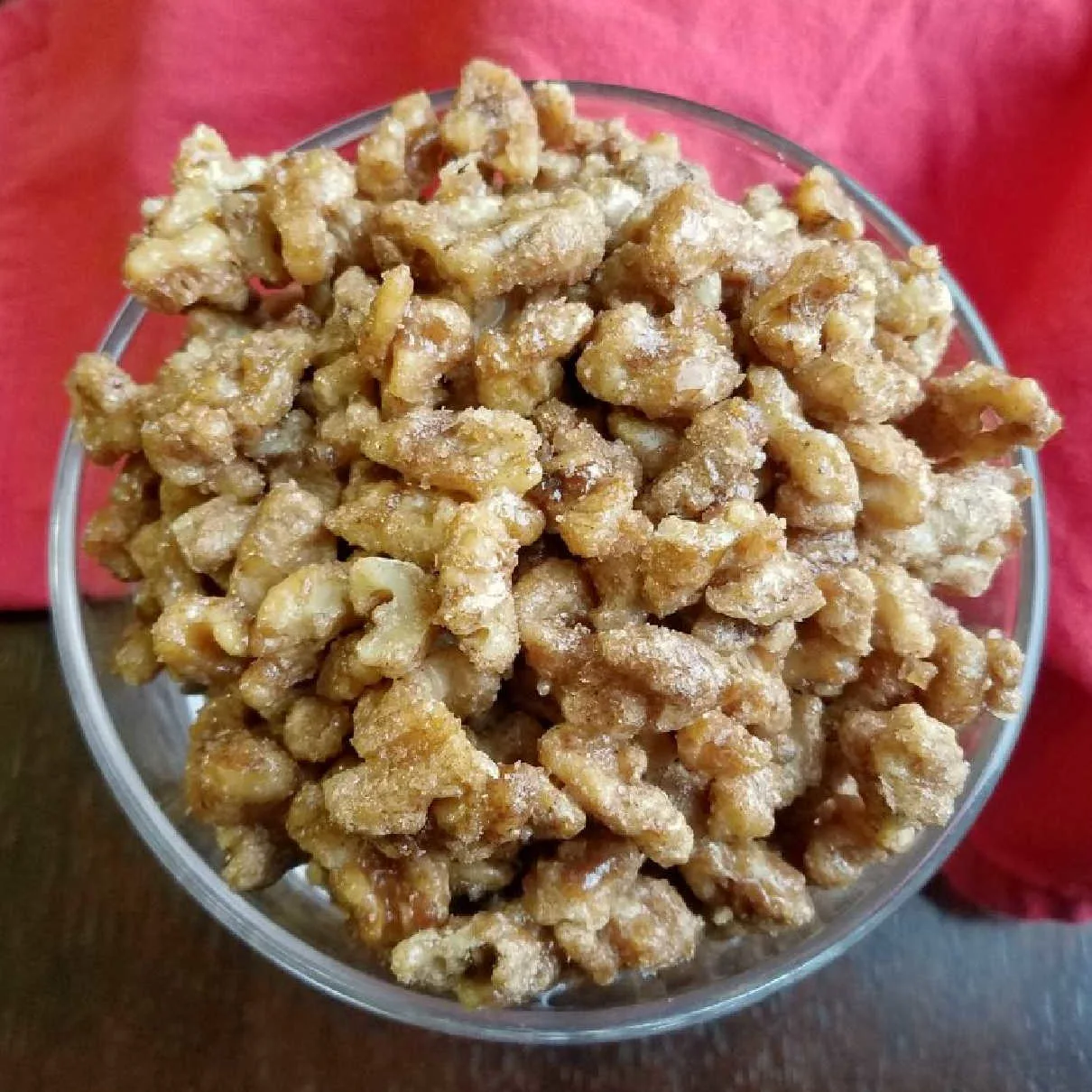 bowl full of candied walnuts with cinnamon and spices on them.