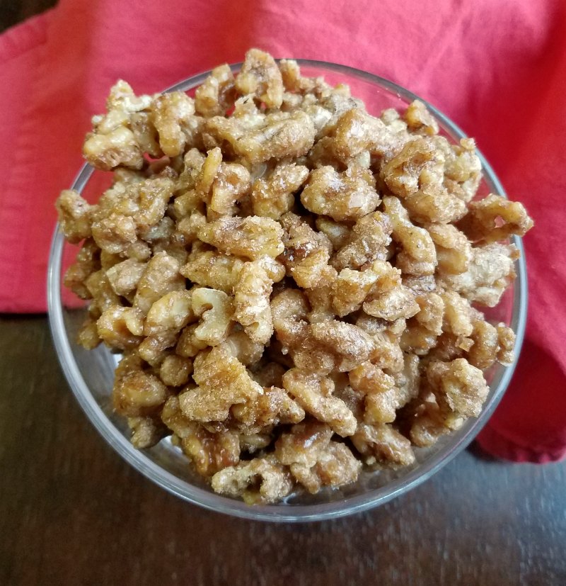 bowl full of candied walnuts with cinnamon and spices on them