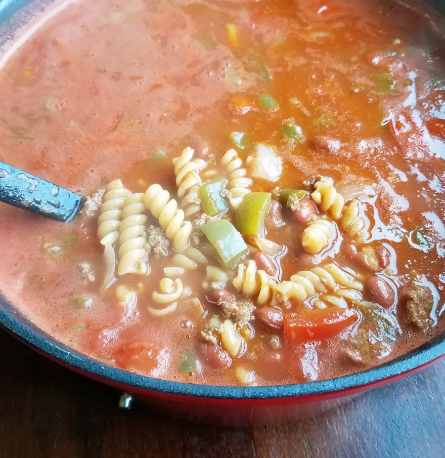 spoonful of chili mac soup being lifted out of pot.