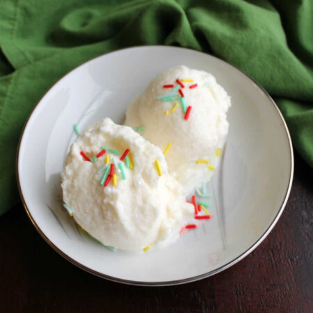 Sweetened Condensed Milk Snow Ice Cream 1 small bowl with two scoops of snow ice cream and colorful sprinkles.