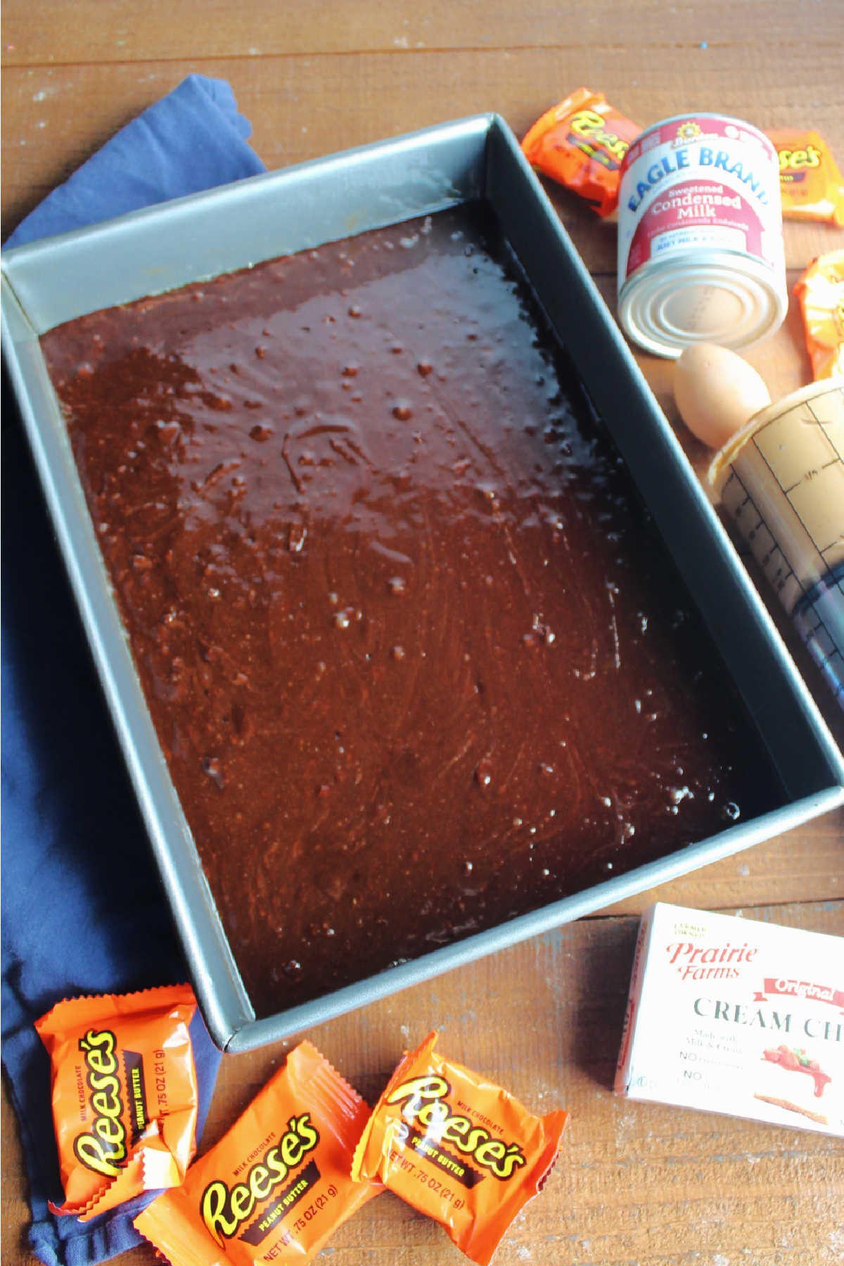 Brownie batter in 9x13-inch pan with other ingredients nearby.