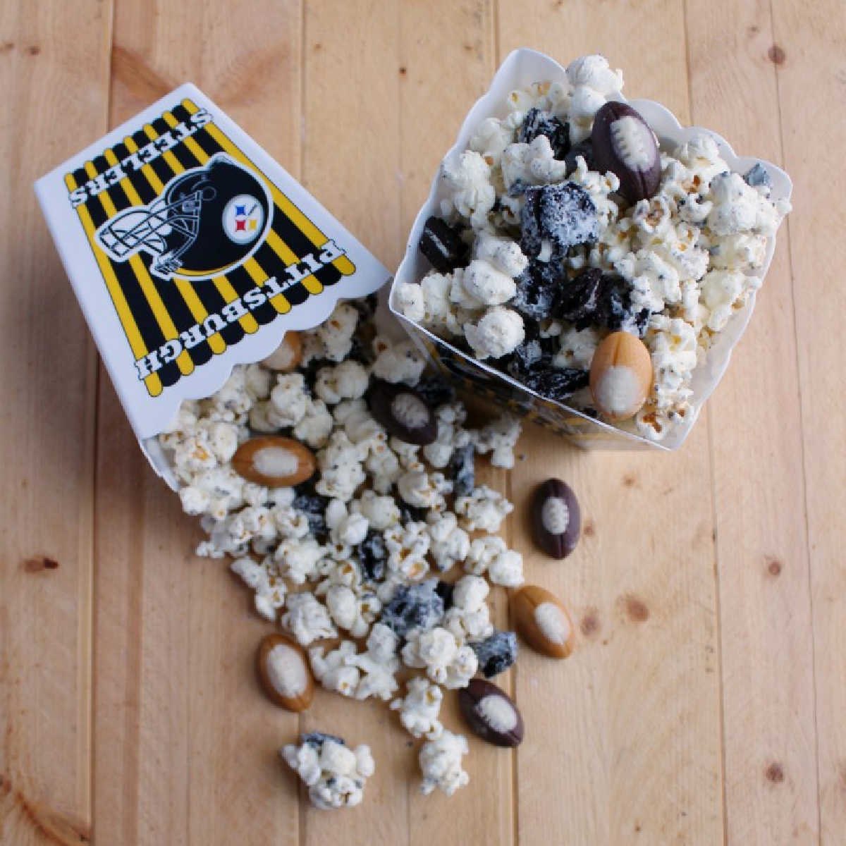 Plastic tubs of cookies and cream popcorn with white chocolate and bits of Oreo cookies, ready to eat.