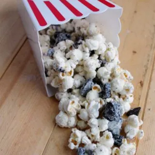 container of white chocolate and cookie popcorn spilling out.