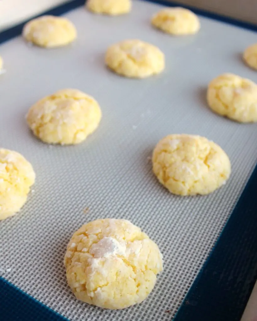 tray of freshly baked powdered sugar coated lemon cookies.
