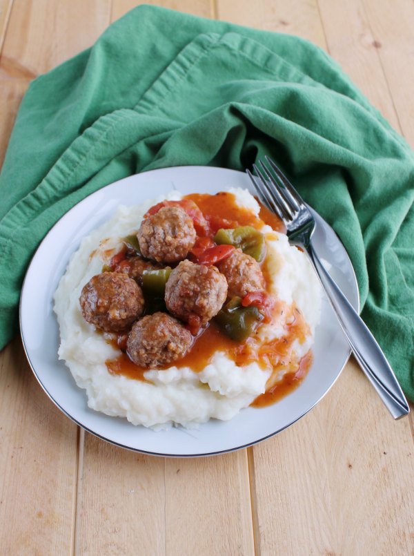 plate with mashed potatoes topped with swiss steak style meatballs