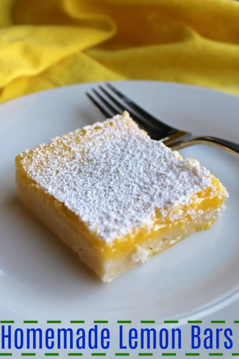 close up of lemon bar with shortbread crust and powdered sugar dusted on top.