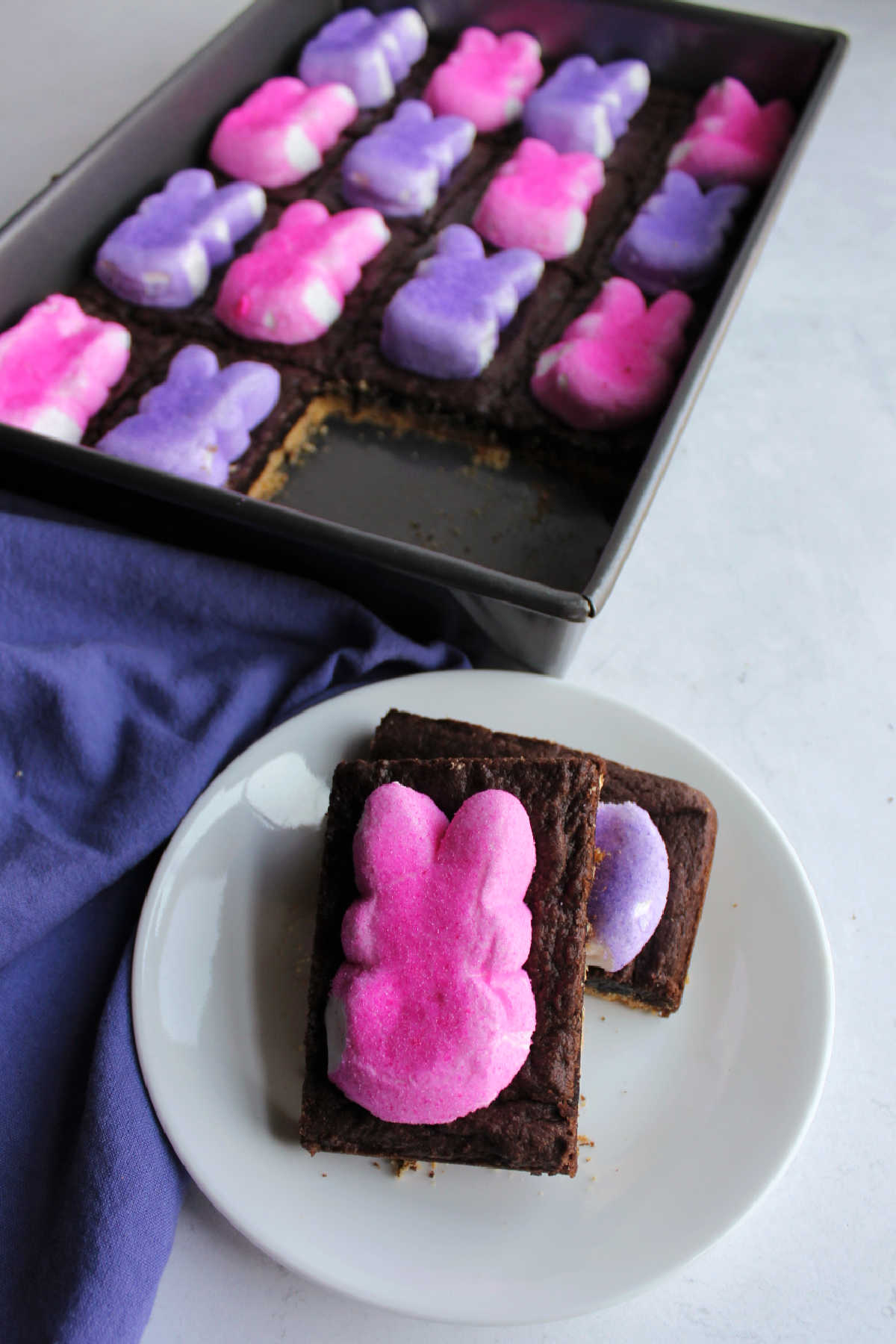 Peep smore bars with pink and purple bunny peeps, a gooey chocolate layer and graham cracker base.