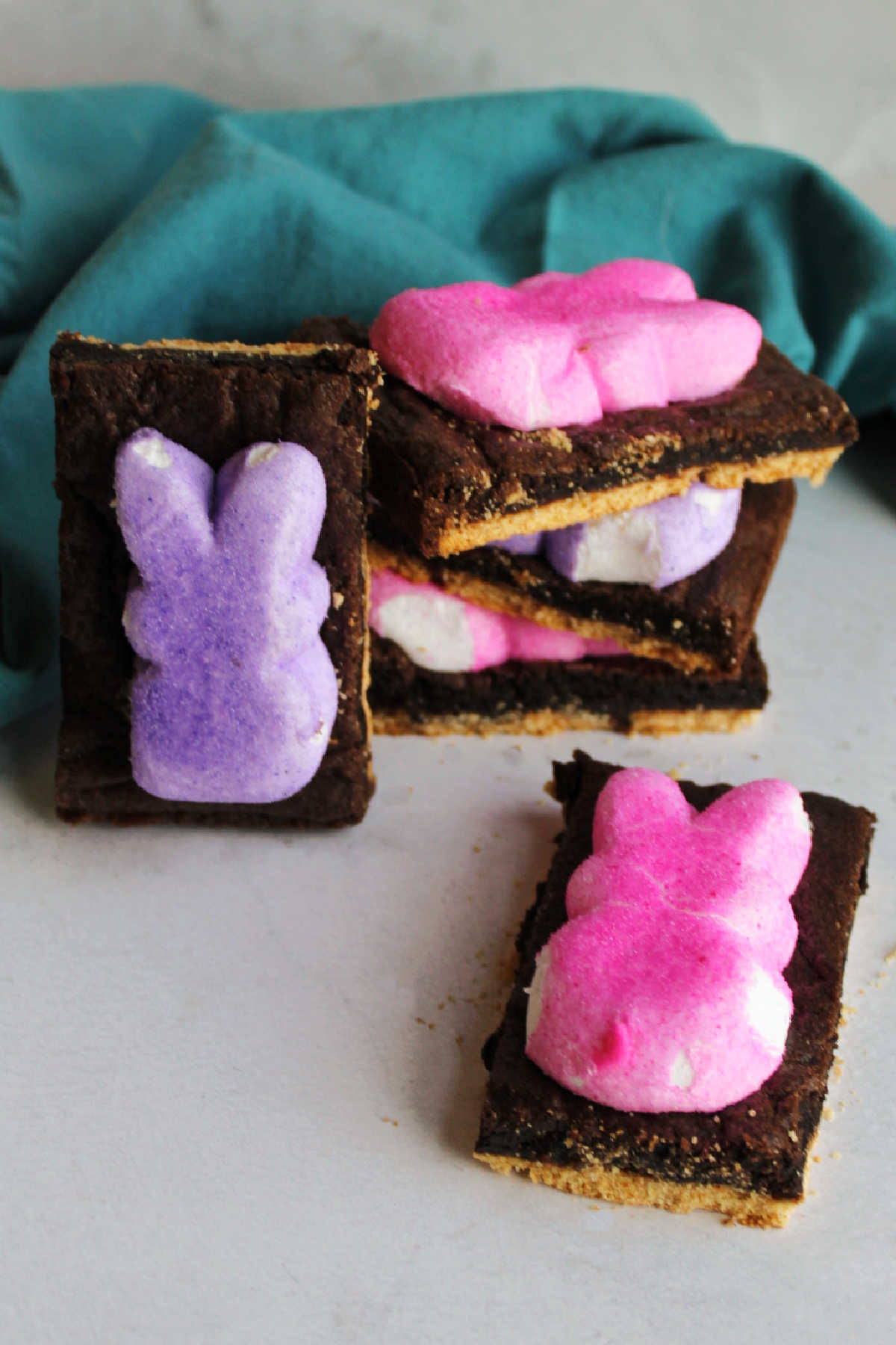 Chocolate cake mix s'mores bars topped with pink and purple peeps bunnies, ready to eat.