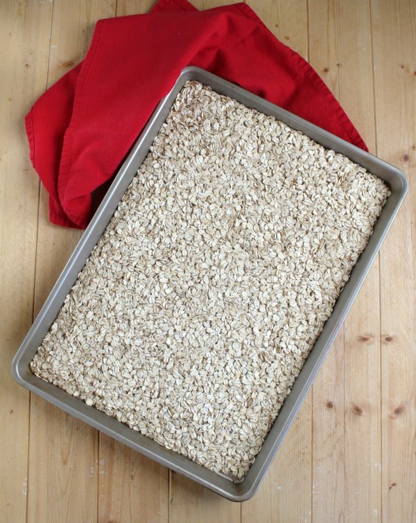 sheet pan filled with lightly toasted oatmeal to make granola.