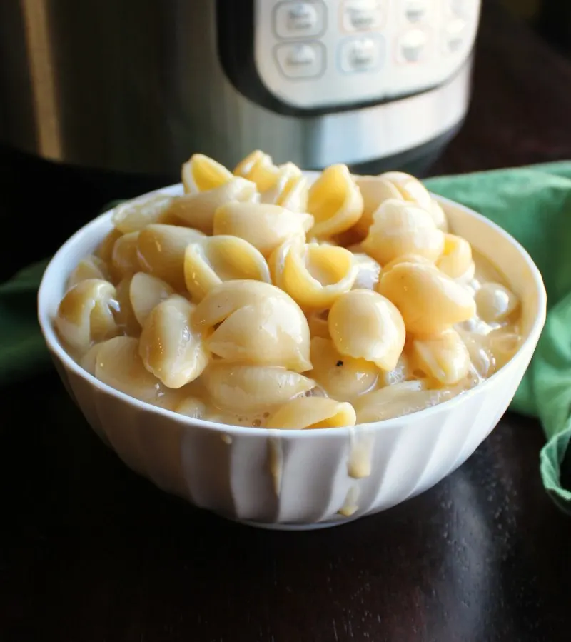 bowl of macaroni and cheese in front of pressure cooker.