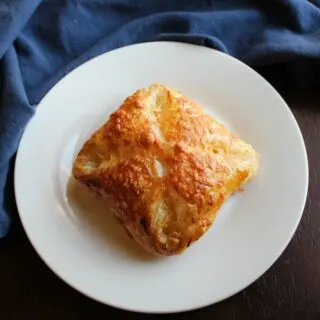 golden brown ham egg and cheese hand pie on plate.