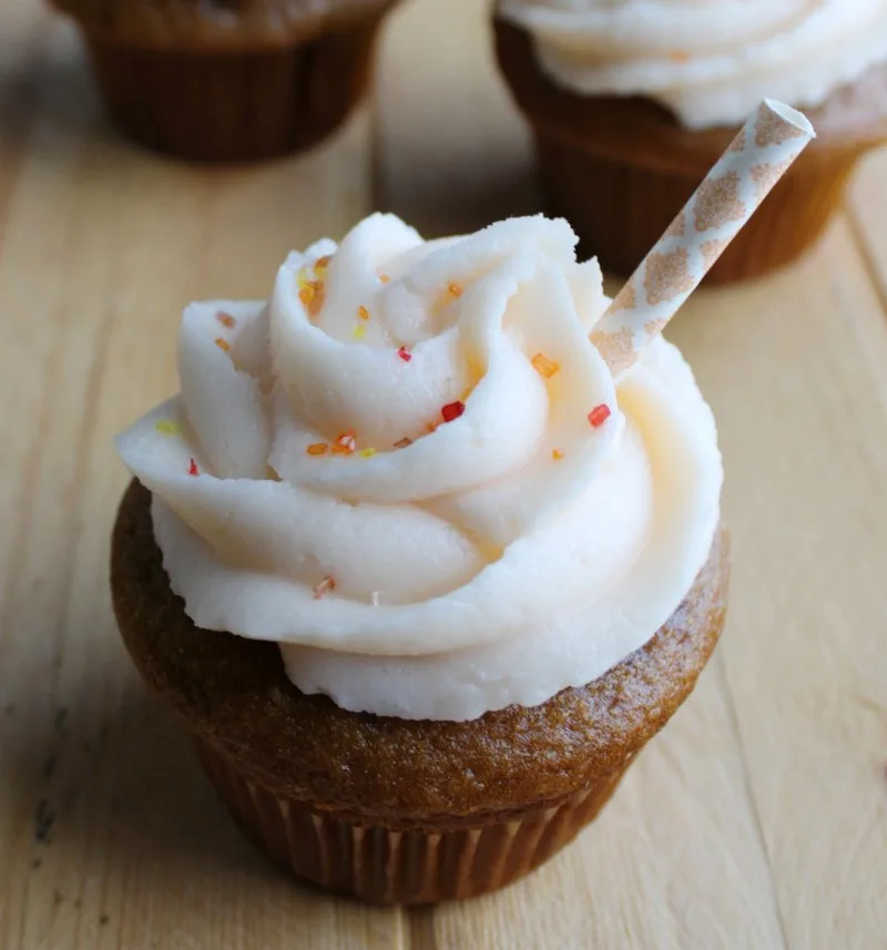 swirl of peach frosting on sweet tea cupcakes with a paper straw for decoration. 