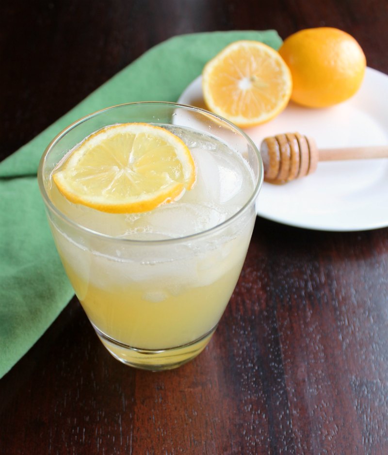 glass of honey lemonade on ice with floating lemon slice 