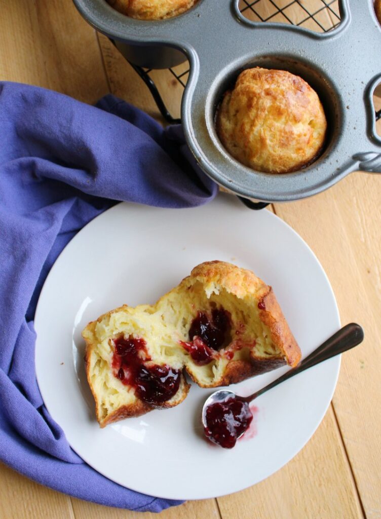 Inside of white cheddar popover with spoonful of raspberry preserves.