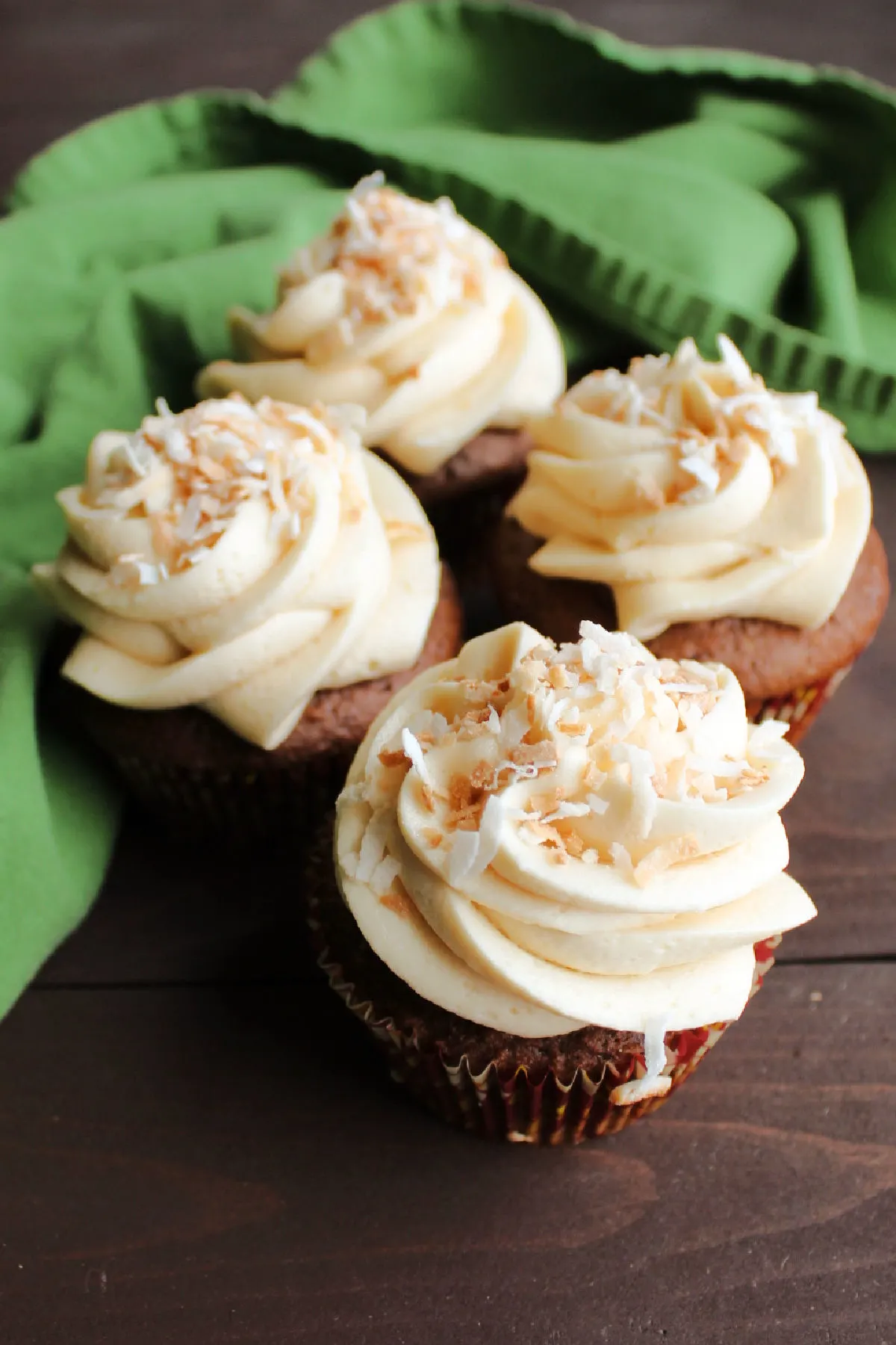 chocolate cupcakes with swirls of caramel buttercream and toasted coconut on top.