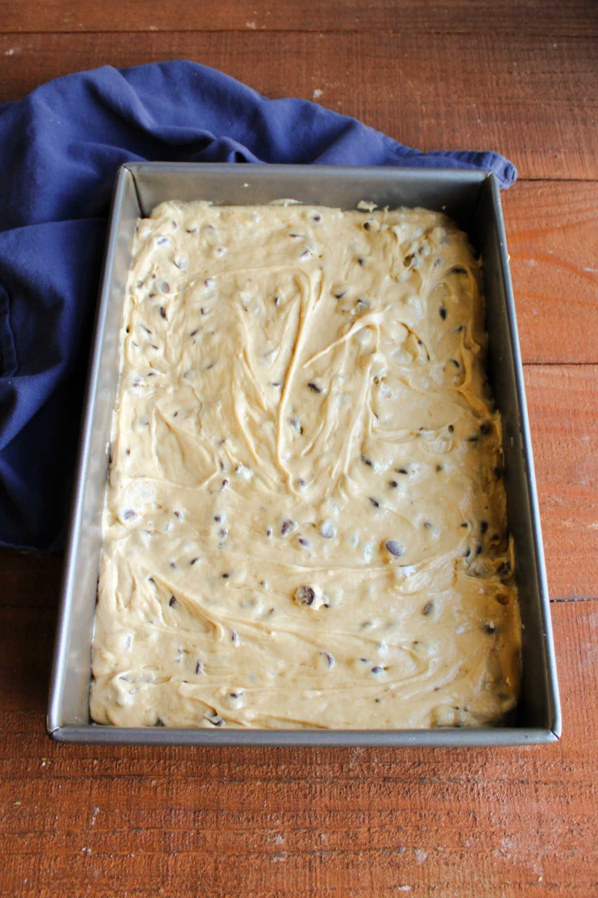 Brown sugar bar dough pressed into a 9x13-inch pan, ready to bake.