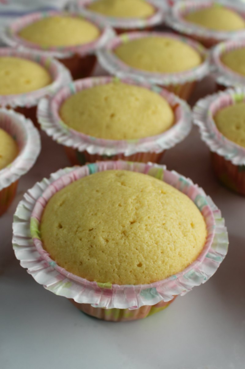 baked butter vanilla cupcakes in frilly liners.