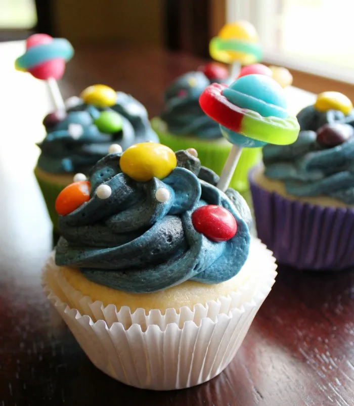 cupcakes with blue and black frosting, candy planets and sucker saturns