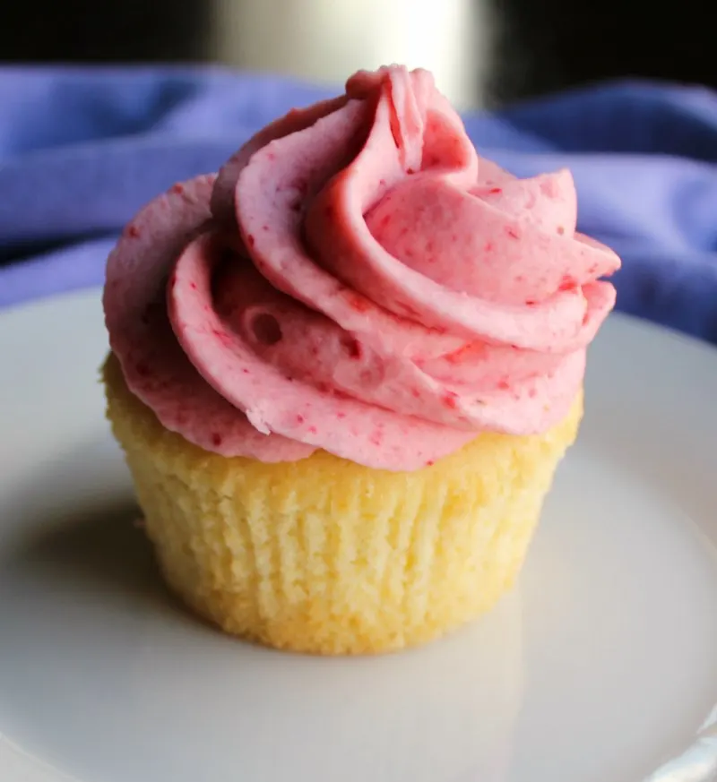 vanilla cupcake topped with swirl of pink strawberry buttercream.