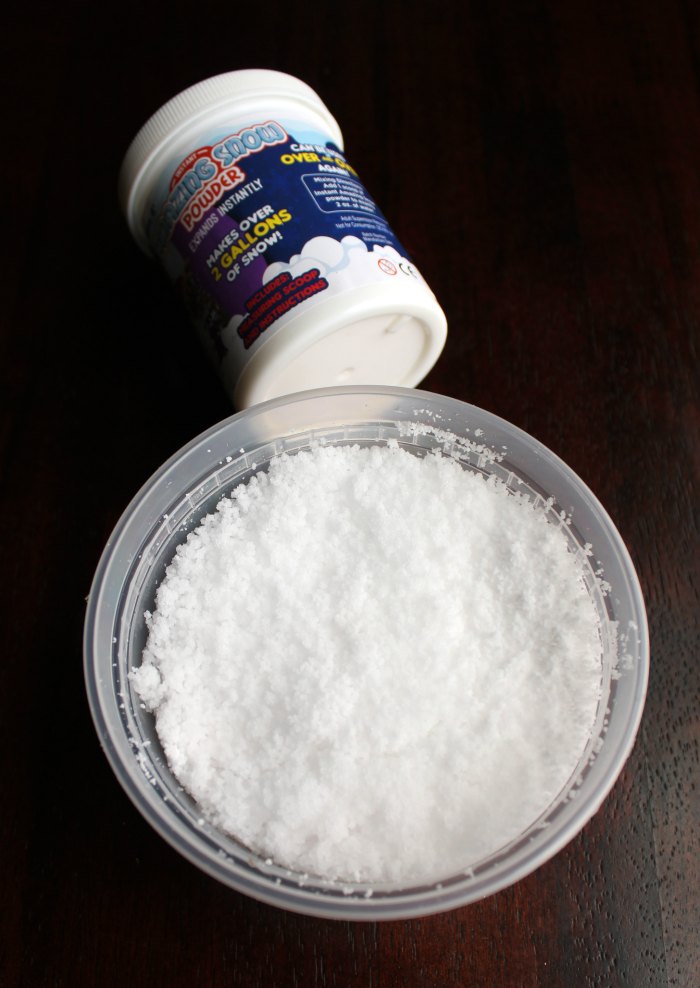 play snow in a tub with container of powder behind it.