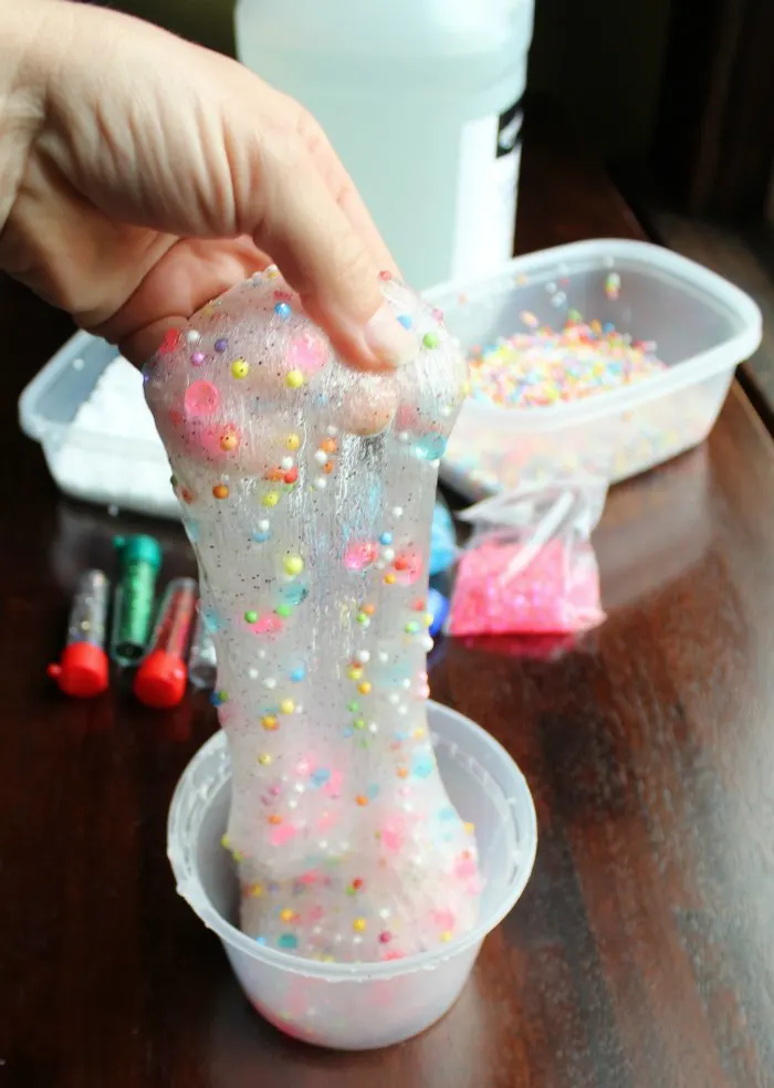 slime using clear glue, baking soda and contact solution with glitter and styrofoam balls.