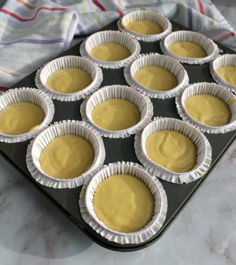 yellow cupcake batter in cupcake liners ready to bake.