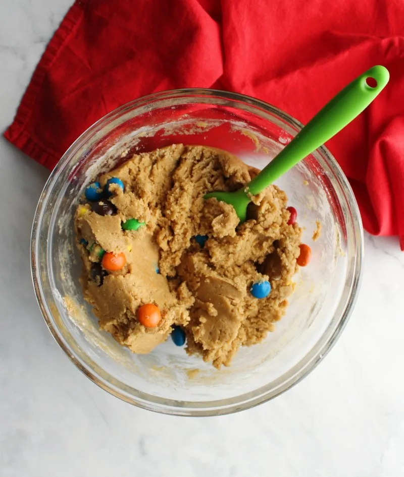 Mixing bowl full of peanut butter cookie dough and peanut butter m&ms.