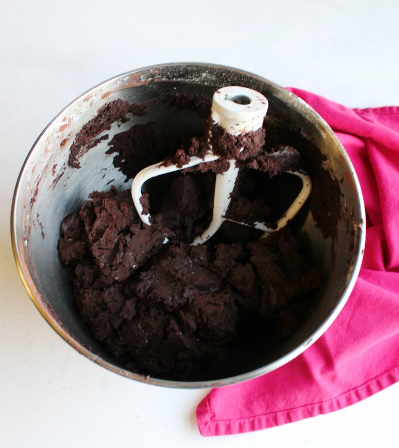 bowl of dark chocolate cookie dough with mixer paddle.