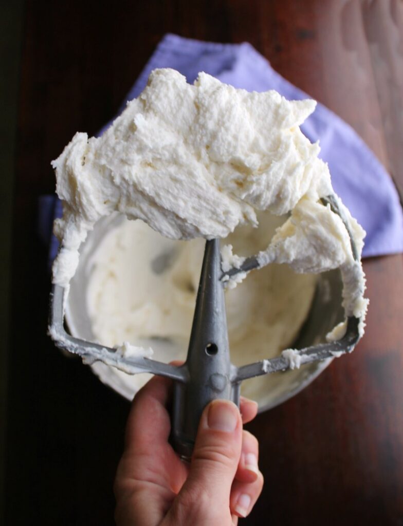 mixer paddle filled with stiff but fluffy cream cheese frosting.