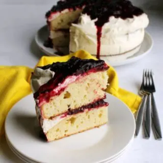 slice of blackberry shortcake cake served on plate with remaining cake in background.