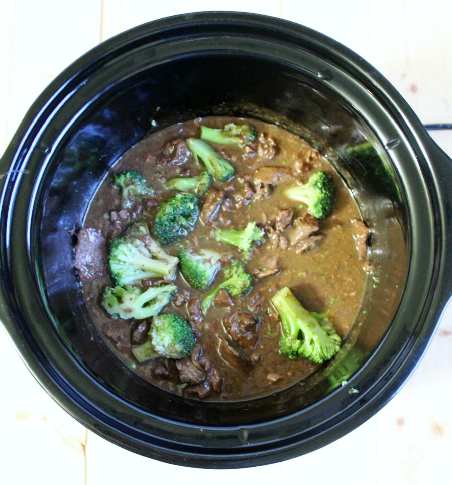 Adding broccoli to cooked backstrap and sauce in slow cooker.
