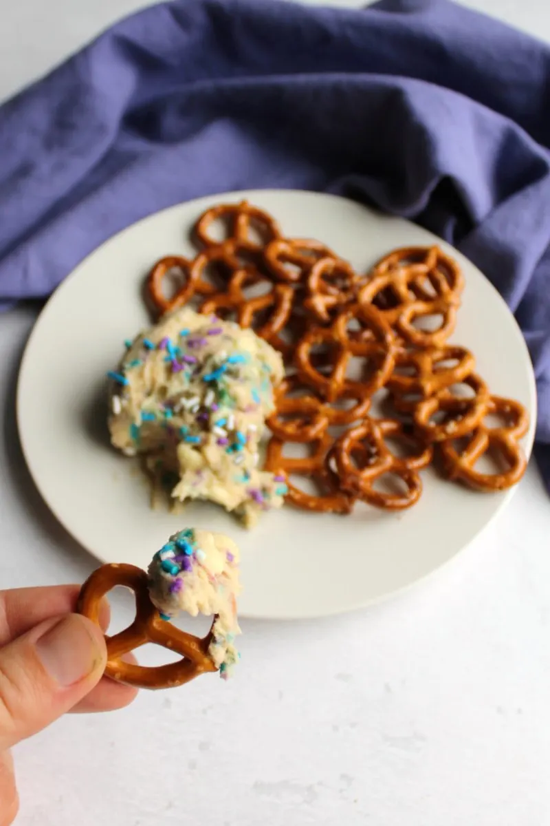 sprinkle filled cookie dough dip on small plate with pretzels for dippers.