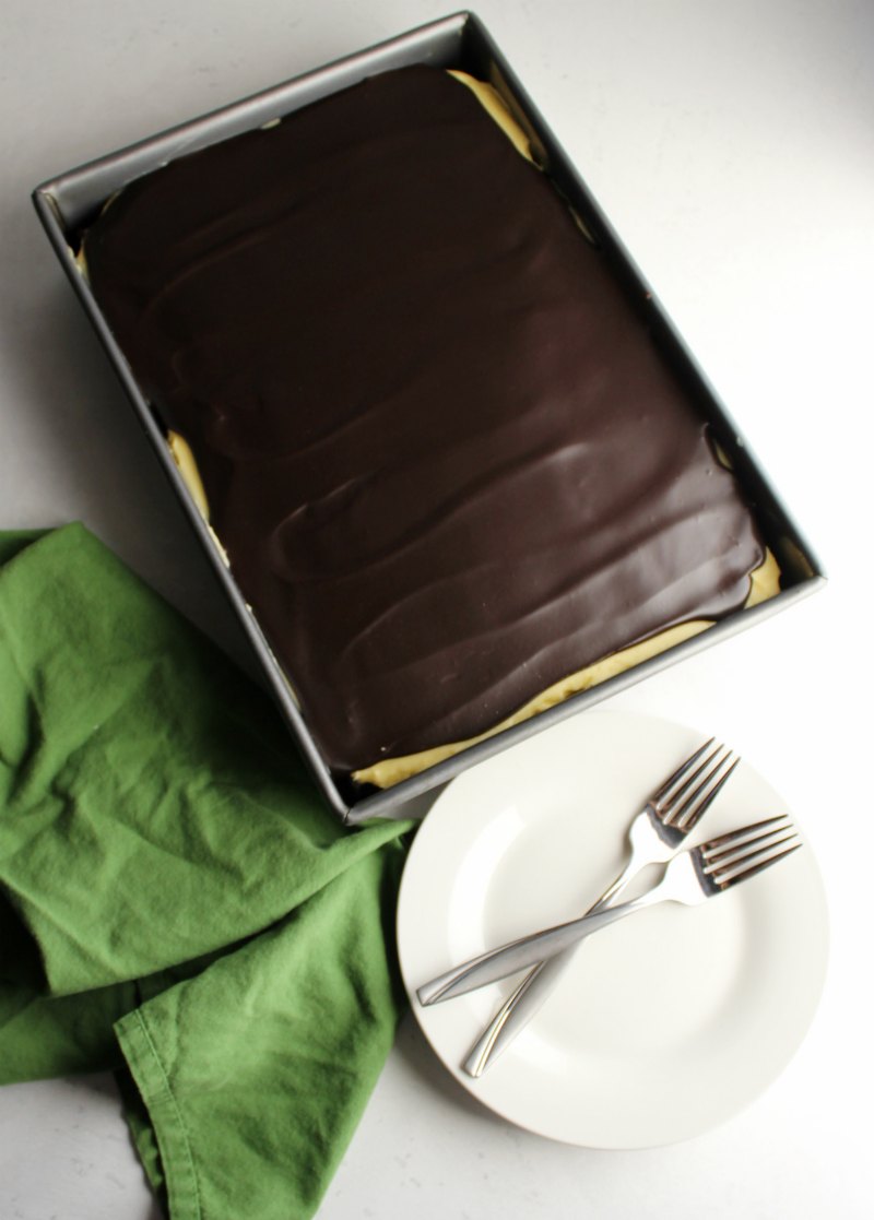 Whole sheet cake topped with shiny chocolate ganache, ready to be served.