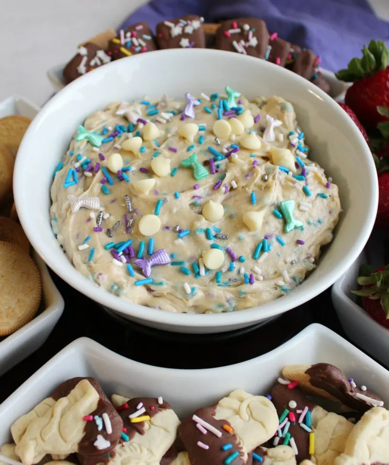 Bowl of cookie dough dip with lots of colorful sprinkles and white chocolate chips.