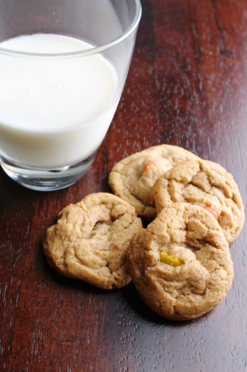four triple peanut butter cookies next to a glass of milk.