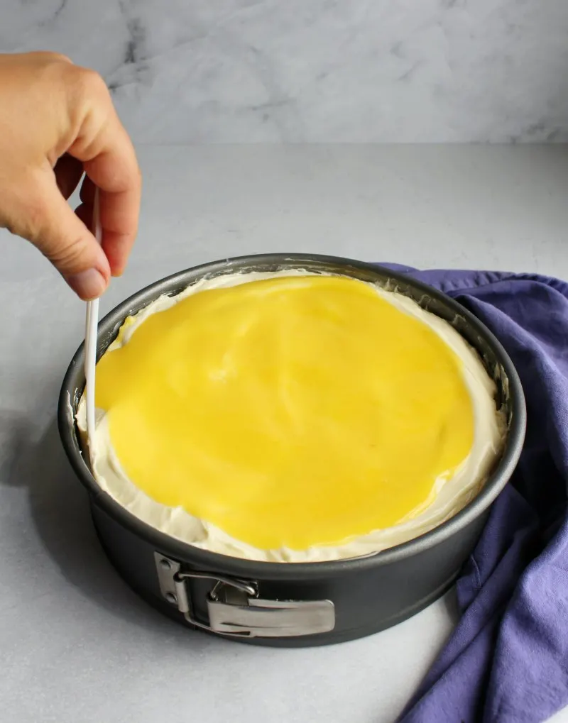 running a knife around the outside of the cheesecake to release it from the pan.