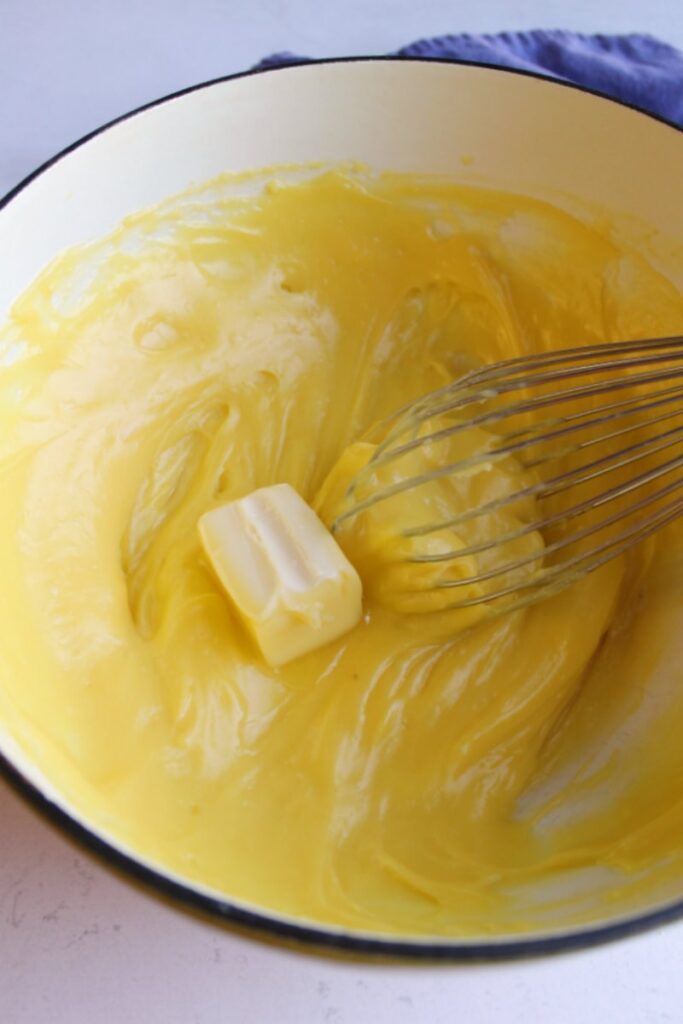 Beating a little bit of butter into custard mixture.