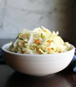 bowl of tangy vinegar based coleslaw with bell pepper, carrots, onion and cabbage.